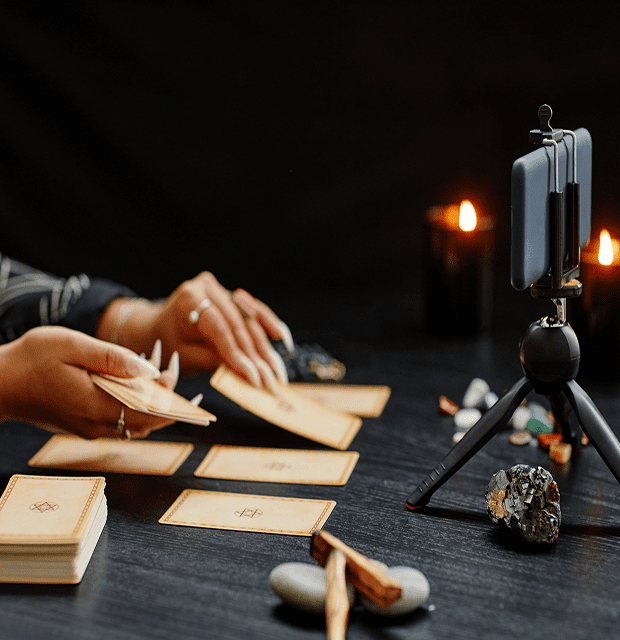 Tarot card reading with candles and phone.